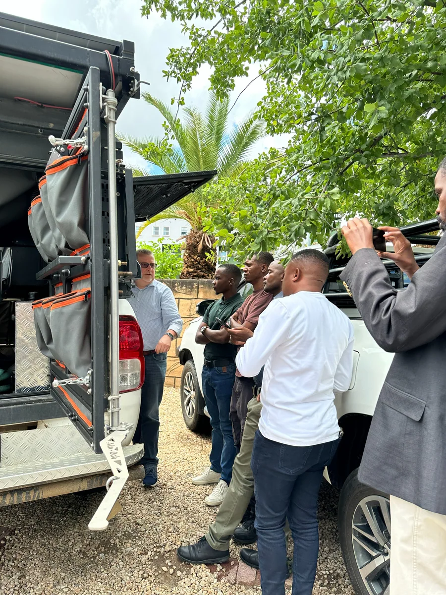 A group viewing the equipment fitted to the rear of the mobile health platform
